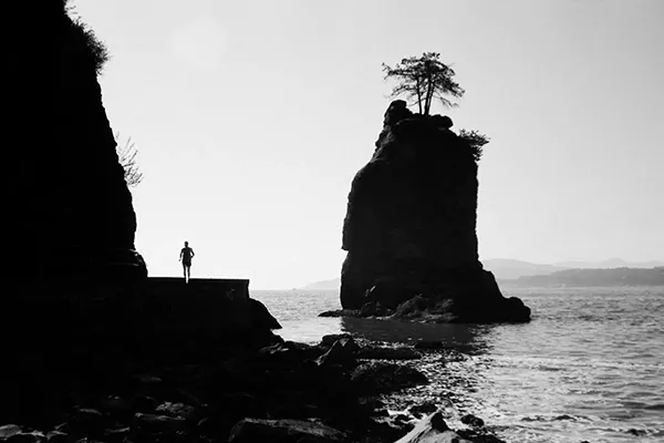 black and white picture of a runner silhouette on the waterfront in Stanley Park in vancouver